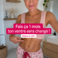 Femme souriante affichant un ventre tonique après un mois d'efforts