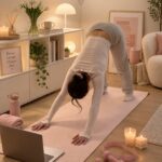 Femme pratiquant le Pilates dans son salon, montrant une posture de renforcement musculaire.